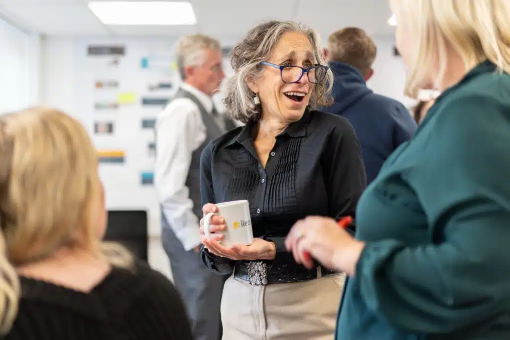 Jayne Jones Laughing Holding A Coffee During An Ilecs Brand Day Discussion